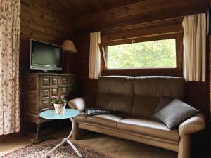 a living room with a couch and a window at Gemütliches Blockhaus in Eschede bei Lüneburg in Eschede