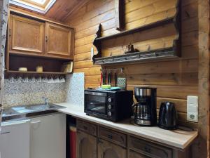 a kitchen with wooden cabinets and a black appliance at Gemütliches Blockhaus in Eschede bei Lüneburg in Eschede +32 photos