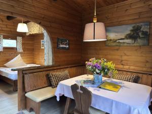a dining room with a table and two beds at Gemütliches Blockhaus in Eschede bei Lüneburg in Eschede