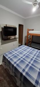 a bedroom with a bed and a flat screen tv at Villa Serena in Nova Odessa +3 photos