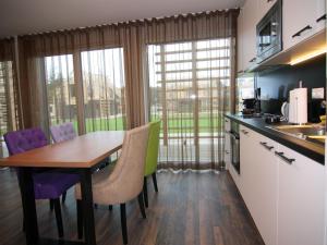 a kitchen with a wooden table and purple chairs at Reihenhaus Reiterchalet in Wendorf in Wendorf