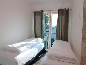 two beds in a room with a window at Chalet mit Außensauna in Wendorf in Wendorf