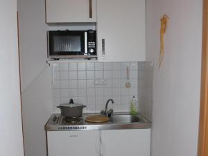 a small kitchen with a sink and a microwave at Gemütliche tierfreundliche Wohnung in Huddingen in Gellershausen