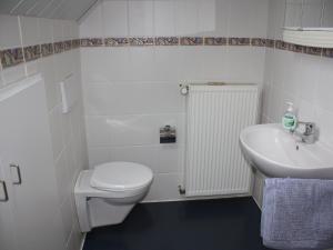 a white bathroom with a toilet and a sink at Gemütliche tierfreundliche Wohnung in Huddingen in Gellershausen +32 photos