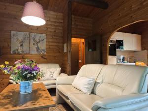 a living room with a couch and a table with flowers at Charmantes Ferienhaus mit Terrasse in der Südheide in Eschede +31 photos