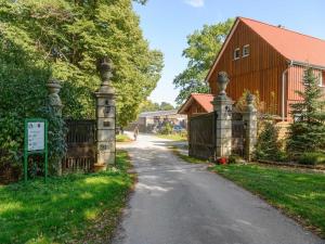a driveway with a gate and a house with a barn at Charmantes Ferienhaus mit Terrasse in der Südheide in Eschede