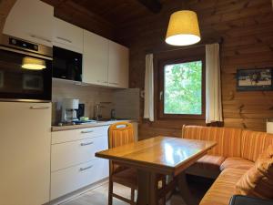 a kitchen and dining room with a table and a couch at Charmantes Ferienhaus mit Terrasse in der Südheide in Eschede