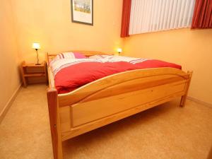 韦耶达Ferienwohnung im Haus Schiefertal, Wieda的一间卧室配有一张带红色毯子的木床