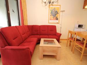 韦耶达Ferienwohnung im Haus Schiefertal, Wieda的客厅里有一张红色的沙发和一张桌子