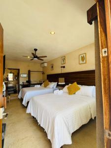 a bedroom with three beds and a ceiling fan at Casa Hamaca Nayarit in Chacala +32 photos