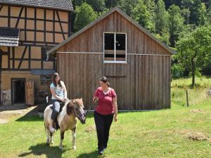 two women walking a horse and a woman riding it at Wohnung mit Terrasse in Hüddingen in Gellershausen