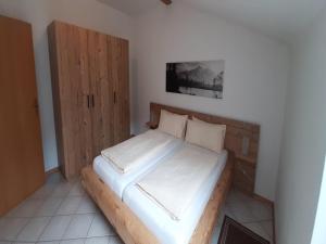 a bedroom with a bed and a wooden cabinet at Stay in Alpine Bayrischzell in Bayrischzell