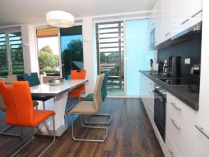 a kitchen with orange and green chairs and a table at Chalet mit Außensauna in Wendorf in Wendorf +25 photos