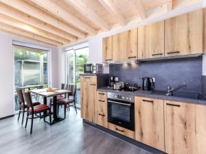 HallschlagHallschlag Lakeside Hideaway的厨房配有木制橱柜和桌椅