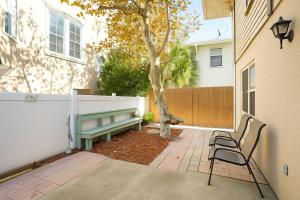 a patio with two chairs and a bench in front of a house at Beachside Bliss - Neptune Nook Unit 2 in Jacksonville Beach