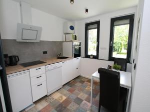 een keuken met witte kasten en een kookplaat oven bij Ferienhaus direkt an der Spree in Frauenberg