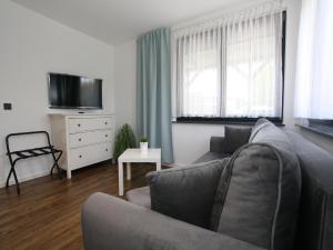 een woonkamer met een bank en een tv bij Ferienhaus direkt an der Spree in Frauenberg