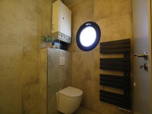 een badkamer met een toilet en een rond raam bij Ferienhaus direkt an der Spree in Frauenberg +19 foto's