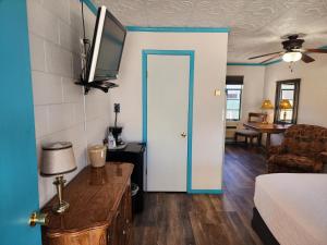 a room with a room with a bed and a door at Arrowhead Motel and RV Park in Ruidoso