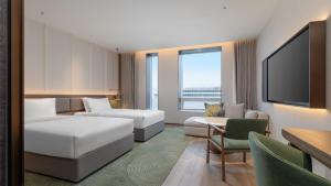 a hotel room with two beds and a flat screen tv at Holiday Inn Wenzhou Airport by IHG in Wenzhou +42 photos