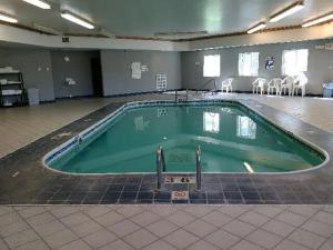 a large swimming pool in a room with chairs at Eastwood Inn in Motley