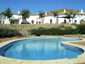 a swimming pool with a house in the background at Cave House in Guadix with Private Pool in Bejarín +17 photos