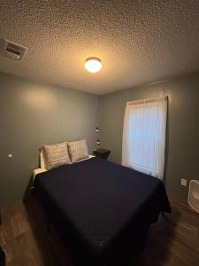 a bedroom with a black bed and a window at Sweet retreat in the springs NOT waterfront property in Homosassa