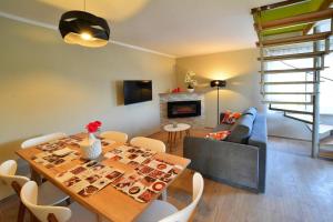 a living room with a dining room table and a staircase at Holiday Home near Ko obrzeg with Private Pond in Nieżyn