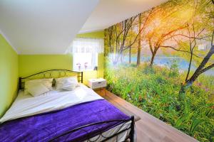 a bedroom with a bed with a painting on the wall at Holiday Home near Ko obrzeg with Private Pond in Nieżyn