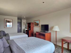 コロラドスプリングスにあるOlympia Innのベッド2台と薄型テレビ付きのホテルの部屋