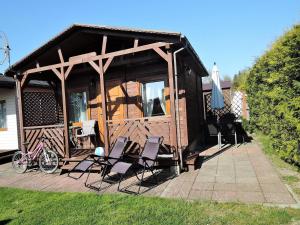 科乌切沃Holiday Home in Kolczewo near Baltic Sea的一间带椅子、遮阳伞和自行车的小屋