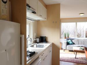 a kitchen with a sink and a living room at Beautiful chalet between golf course and beach in Hollum