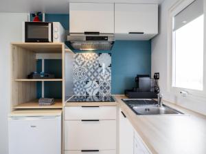 Una cocina con gabinetes blancos, un fregadero y un microondas. en Chalet in Nature, Friesland, en De Veenhoop 32 fotos más