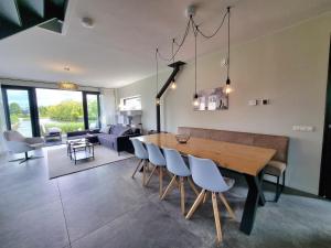 BalkWaterfront Villa w Jetty的配有木桌椅的餐厅和客厅