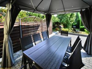 a wooden table and chairs under an umbrella on a patio at Comfortable holiday home with a garden, Kolobrzeg in Luboszyce +15 photos