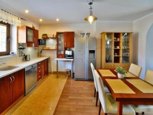 a kitchen and dining room with a table and refrigerator at Comfortable holiday home with a garden, Kolobrzeg in Luboszyce