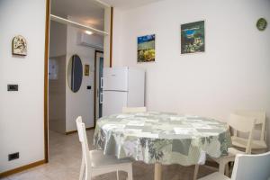 Marina di Santa CroceHoliday home in Eraclea Mare 25653的配有桌椅和冰箱的厨房 更多24张照片