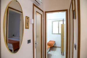 Marina di Santa CroceHoliday home in Eraclea Mare 25653的走廊上设有镜子,房间设有床