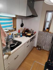 a kitchen with a sink and a counter top at 関東最大のスパが身近にあり二部 in Niizo