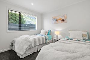 Ένα ή περισσότερα κρεβάτια σε δωμάτιο στο Kamo Oasis - Your Modern Home Away From Home