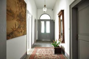 a hallway with a green door and a rug at B&B Casa Carbonara in Cividale del Friuli
