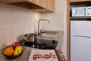 a kitchen with a bowl of fruit on a counter at Quality Suites Saint-Paul-l s-Dax in Saint-Paul-lès-Dax