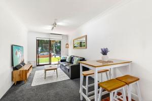 Surf's Up Sawtell في ساوتيل: غرفة معيشة مع أريكة وطاولة