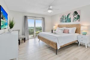Una habitación blanca con una cama y una ventana en Cocoa Beach Towers, en Cocoa Beach