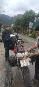 a man is standing next to a motorcycle at Mùa Pửi Lô lô homestay in Mèo Vạc +80 photos