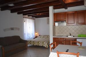 a kitchen and living room with a couch and a bed at Apartments Hedviga in Krk