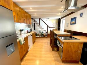 a large kitchen with wooden floors and a staircase at Caribbean Loft - SXM in Anse Marcel 