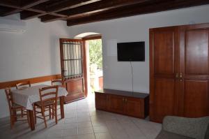 a living room with a table and a television and a table and chairs at Apartments Hedviga in Krk