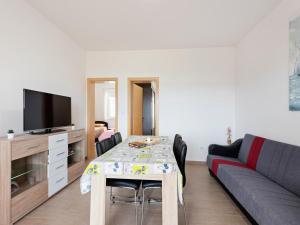 ein Wohnzimmer mit Tisch und Couch in der Unterkunft Apartment in Nevidane near White Mountains in Neviđane