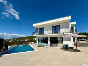 a large white house with a swimming pool and an umbrella at Apartment in Croatia near the Adriatic Coast in Crikvenica